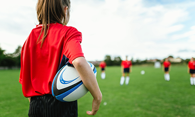 female rugby player preparing to pass a ball on a field representing teamwork and sportmanship in a dynamic game 9 ways to play rugby